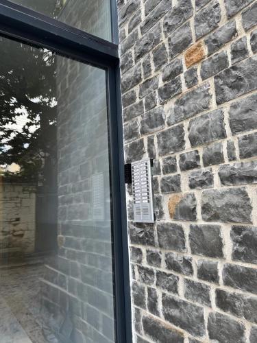 a glass door with a window in a brick wall at ABC Apartments in Korçë