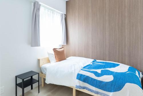Ένα ή περισσότερα κρεβάτια σε δωμάτιο στο Ekimae apartment
