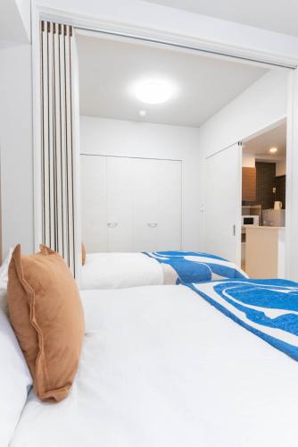 Ένα ή περισσότερα κρεβάτια σε δωμάτιο στο Ekimae apartment