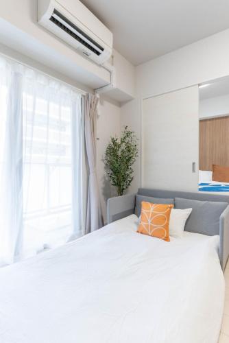 Ένα ή περισσότερα κρεβάτια σε δωμάτιο στο Ekimae apartment