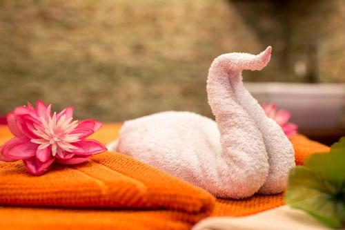 a towel animal sitting on a table with flowers at Golden Royal Boutique Hotel & Spa in Košice