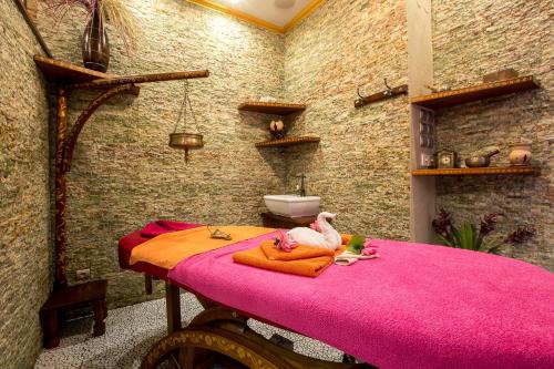 a room with a pink table with a pink blanket at Golden Royal Boutique Hotel & Spa in Košice