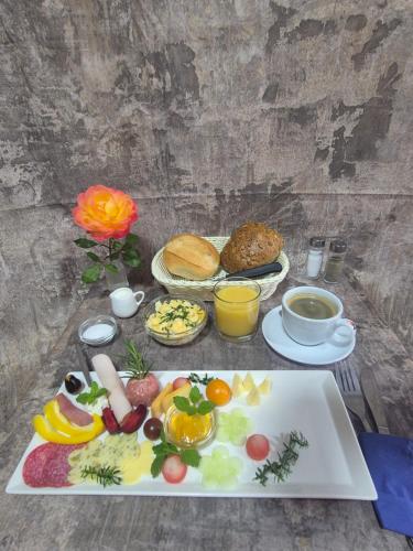 a table with a plate of fruits and vegetables on it at Ferienquartier Forsthaus 2 in Bad Gottleuba