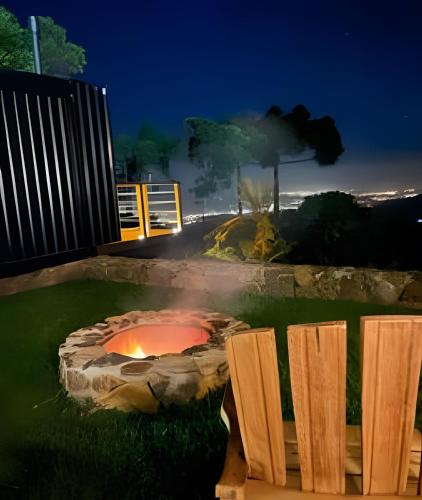 a stone fire pit in a yard at night at Chalé com banheira e lareira - 20 min de Gramado in Igrejinha