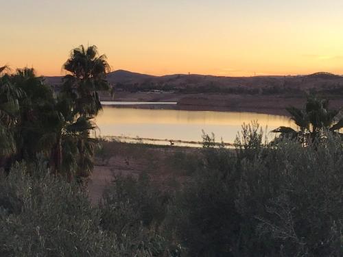 a view of a river at sunset at Dar NFis Suites et chambres de luxe dans un havre de paix vue paradisiaque au bord du lac in Lalla Takerkoust