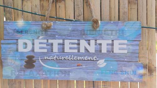 a sign that reads deficit hanging on a wooden wall at Le Jardin D' Épicure in Oderen