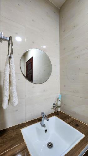 a bathroom with a white sink and a mirror at Golden Castle Hotel Hoima in Hoima