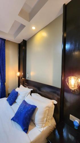 a bedroom with two beds with blue pillows at Golden Castle Hotel Hoima in Hoima