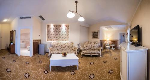 a living room with two chairs and a table and a bed at Golden Royal Boutique Hotel & Spa in Košice