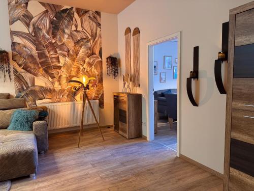 ein Wohnzimmer mit einem großen Federmotiv an der Wand in der Unterkunft Ferienwohnung Chris in Haltern