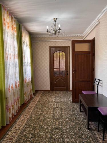 a room with a door and a table and chairs at Cholpon Guest House & Hostel in Toktogul