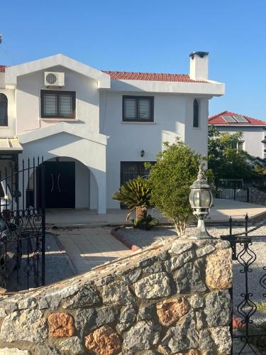 a large white house with a stone wall at Villa for Rent in Kappedhes