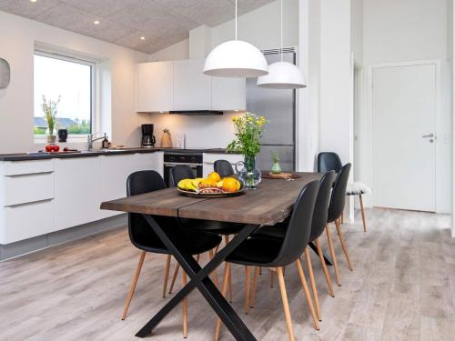 a kitchen and dining room with a wooden table and chairs at 8 person holiday home in Ansager in Ansager