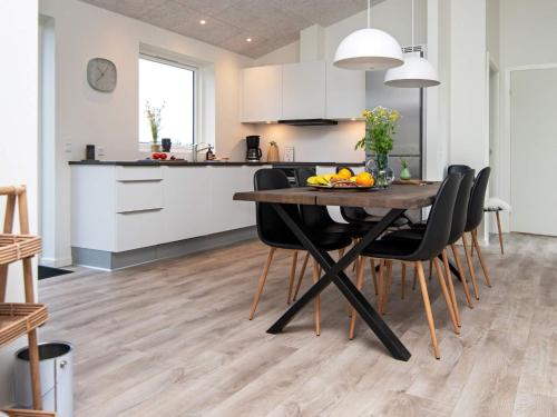 a kitchen and dining room with a wooden table and chairs at 8 person holiday home in Ansager in Ansager
