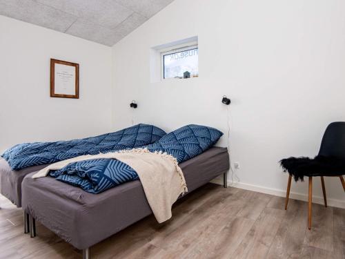 a bed in a room with blue pillows on it at 8 person holiday home in Ansager in Ansager