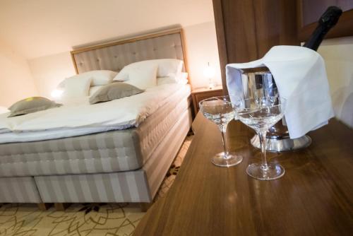 a bedroom with a bed and two wine glasses on a table at Golden Royal Boutique Hotel & Spa in Košice