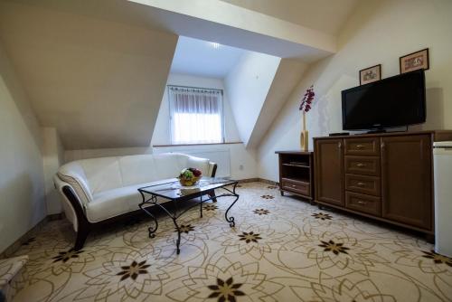 a living room with a couch and a flat screen tv at Golden Royal Boutique Hotel & Spa in Košice