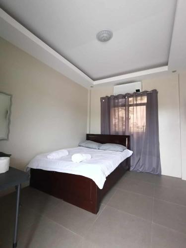 a bedroom with a bed and a window with towels at Wilson Hills Travelers Suites in San Juan