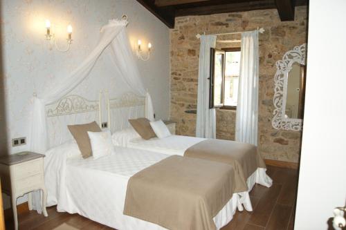 a bedroom with two white beds and a window at A Eira da Laxe in Cerdedo