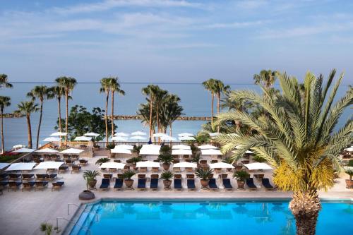 Una vista de un resort con piscina y palmeras. en Annabelle, en Pafos