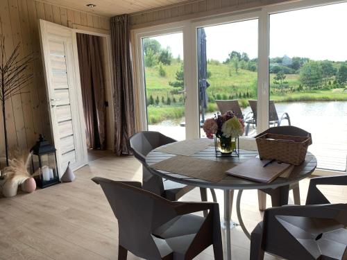 a dining room with a table and chairs and a large window at Aurora Resort in Stasiūnai
