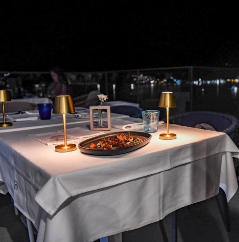 a white table with a plate of food on it at Santa Boka in Perast