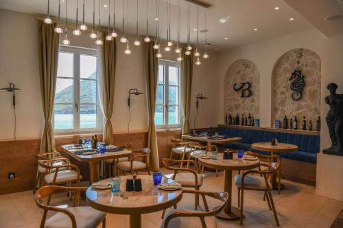 a restaurant with tables and chairs and a bench at Santa Boka in Perast