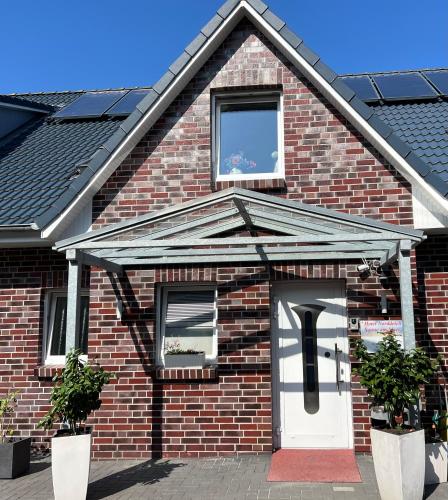a red brick house with a white door at Hotel Sonne am Meer in Norddeich