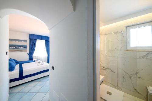 a bathroom with a bed and a glass shower at Hotel Villa Durrueli Resort & Spa in Ischia