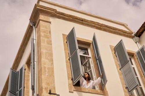 a woman is looking out of a window at Amyth of Nicosia in Nicosia