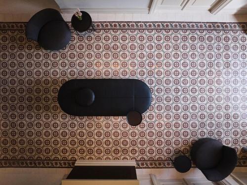 a black chair on a wall with a pattern at Amyth of Nicosia in Nicosia