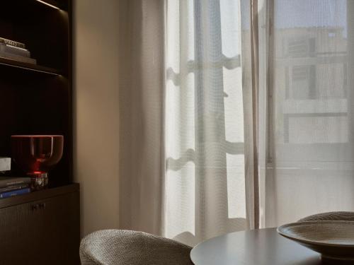 a window with a white curtain and a table and chairs at Amyth of Nicosia in Nicosia