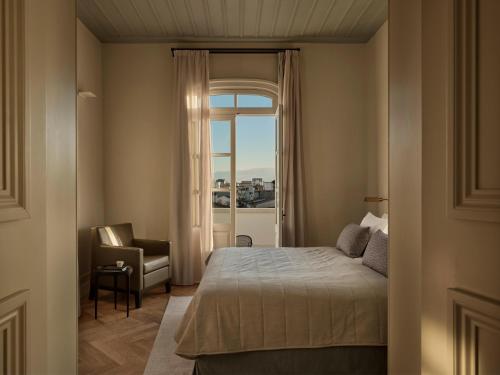 a bedroom with a bed and a chair and a window at Amyth of Nicosia in Nicosia