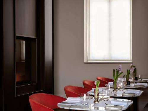 a dining room with tables and red chairs and a window at Amyth of Nicosia in Nicosia