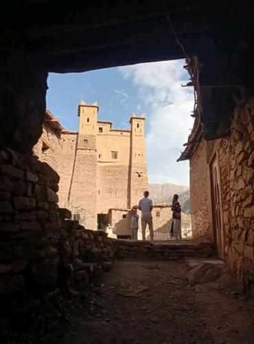 a couple of people standing in an alley way with a castle at gîte taghia ahansal in Taghia