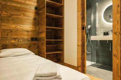 a bedroom with a bed and a glass shower at CHALET TEKA LES GETS - Appartement Ubac in Les Gets