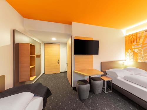 a hotel room with a bed and a tv at B&B HOTEL Hagen in Hagen