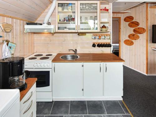 a small kitchen with a sink and a stove at 5 person holiday home in Grindsted in Tofterup