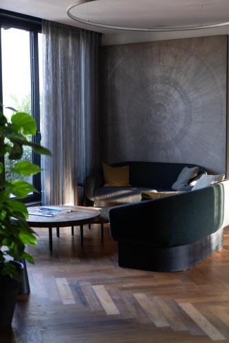 a living room with a couch and a table at Hôtel National Des Arts et Métiers in Paris