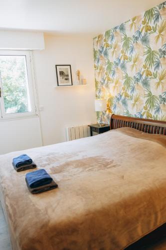 a bedroom with a large bed with two towels on it at Pura Vida, parking sur place, 500m de la mer in Étretat