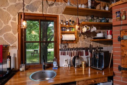 a kitchen counter with a sink and a window at Männisalu cozy houses with hot tube and many extras 