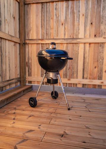 a grill sitting on a stand on a wooden floor at Loxodonta Lodge - Gîte 4 pers proche de Pairi Daiza in Cambron-Casteau