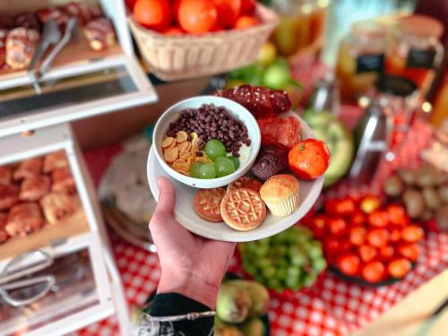 a person holding a plate of food in a store at Ostello Bello Palermo in Palermo