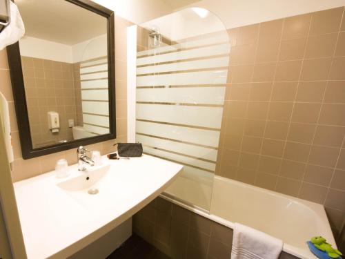 La salle de bains est pourvue d'un lavabo, d'un miroir et d'une baignoire. dans l'établissement ibis Styles Nantes Centre Place Royale, à Nantes