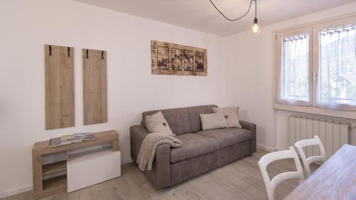 a living room with a couch and a table at Caty's Home in Temù
