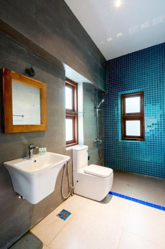 a bathroom with a sink and a toilet at Serendipity in Colombo