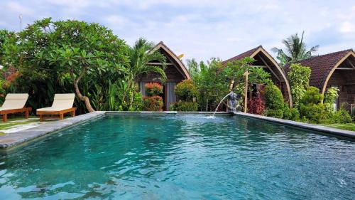 a swimming pool in the backyard of a villa at Umma Bali Menjangan Retreat in Banyuwedang
