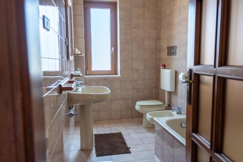 ein Badezimmer mit Waschbecken und Toilette und einem Fenster in der Unterkunft Sun House in Santa Maria del Cedro