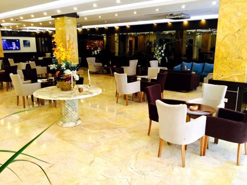 a restaurant with white chairs and tables in a lobby at Grand Palace Hotel Erbil in Erbil