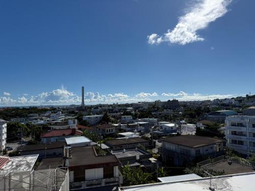 a view of a city with mountains in the background at ハイ沖縄金武店トイレお風呂共用 プレオープン中駐車場有 ペット同伴可能長期滞在可能2025年10月より車貸し出しサービス有希望であればお申し付けください in Kin